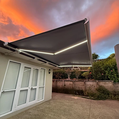 Heavy-duty outdoor drop awning blind providing wind and UV protection on a patio.