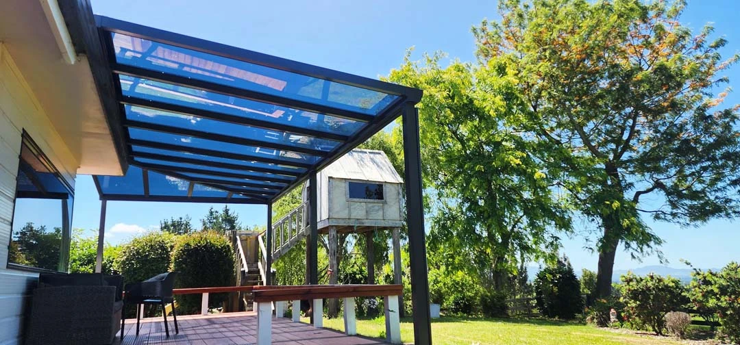 Motorized custom patio shelter protecting a backyard seating area with structural columns.